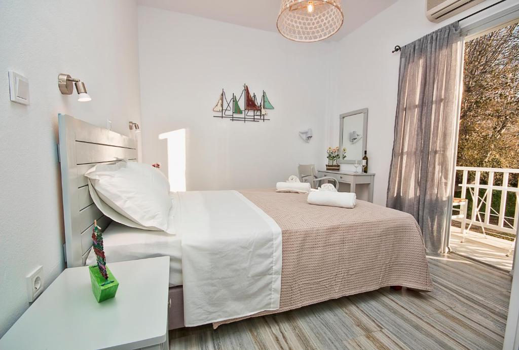 パリキアにあるMerSea apartmentsの白いベッドルーム(ベッド1台、窓付)