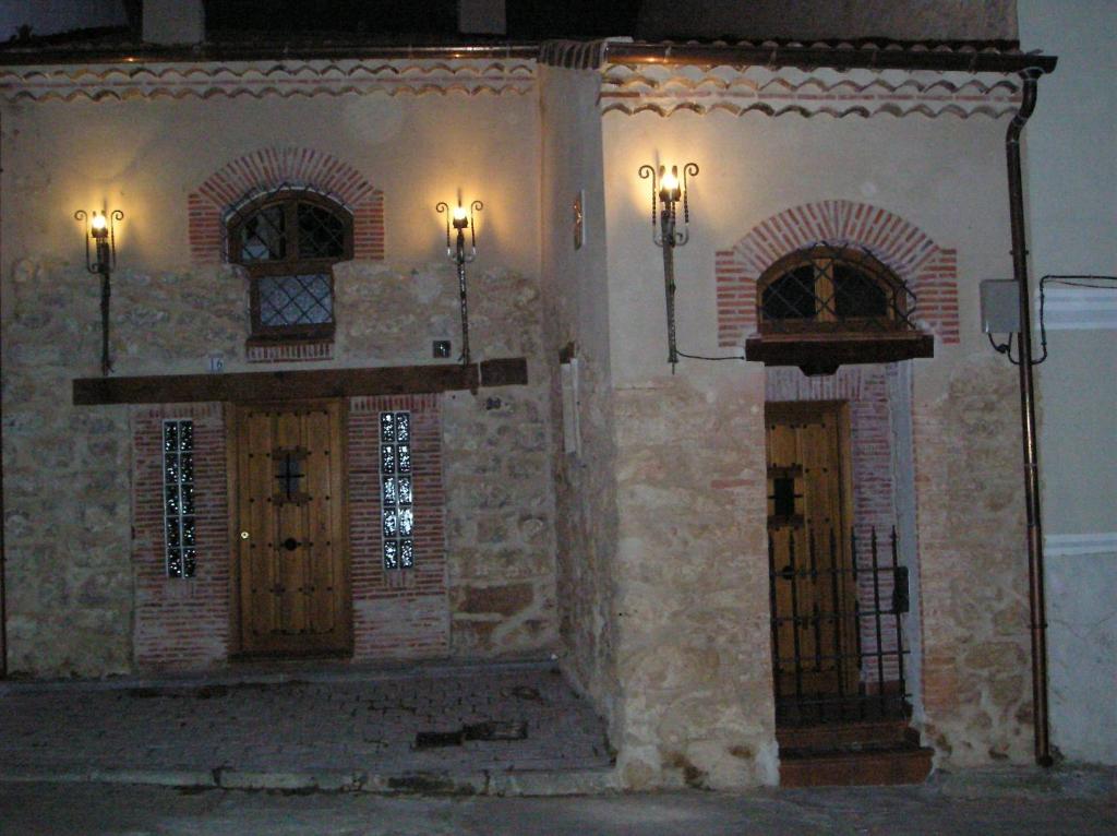 een kerk met twee deuren met een standbeeld erin bij Viejo Horno in Torreiglesias