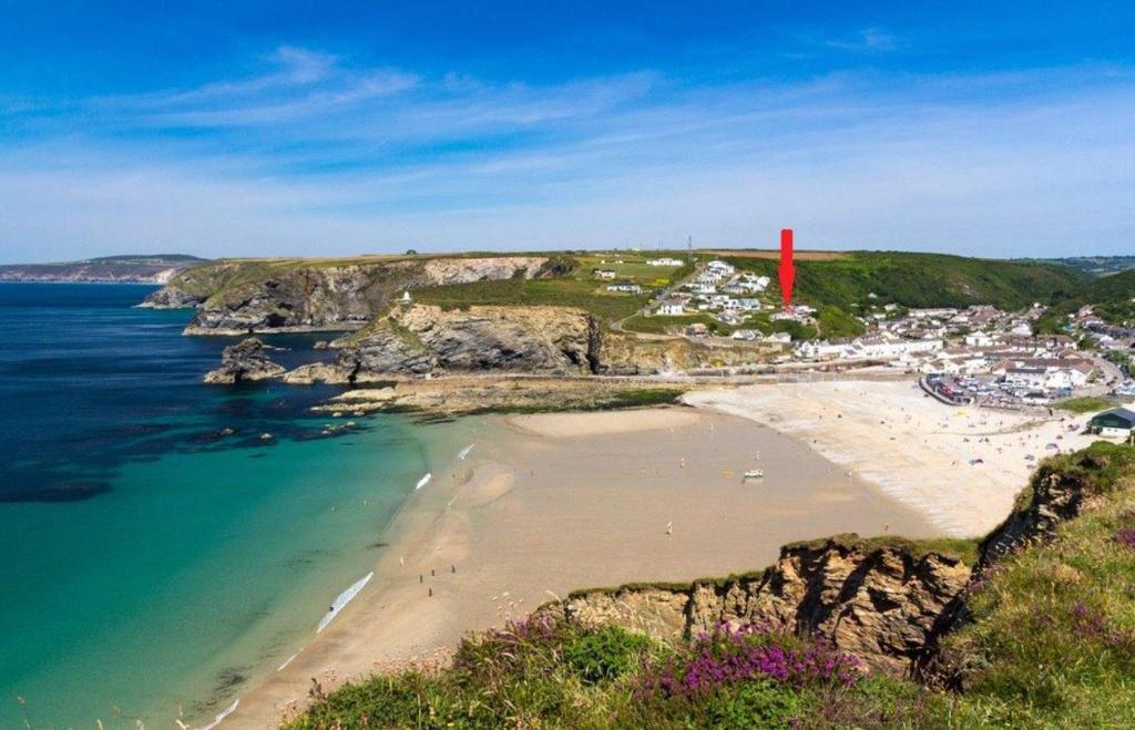 an aerial view of a beach with a red lighthouse at The Haven in Portreath