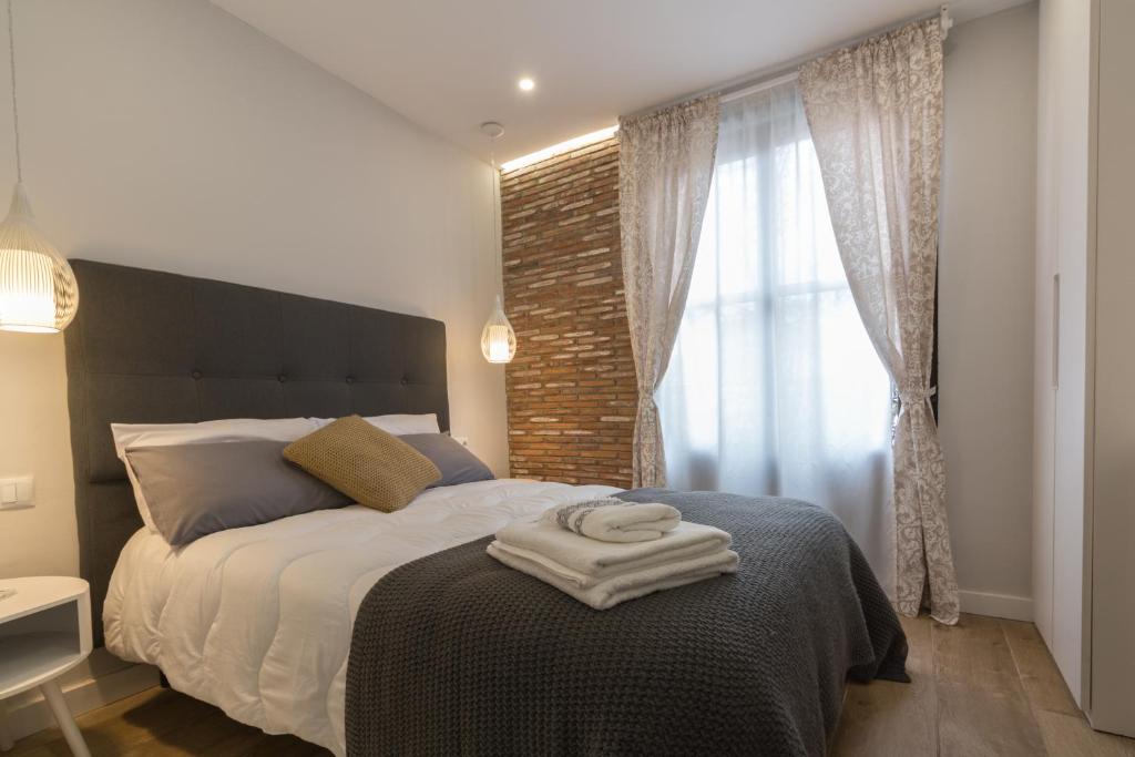 a bedroom with a bed with two towels on it at Apto con vistas a la catedral y aire acondicionado in Logroño