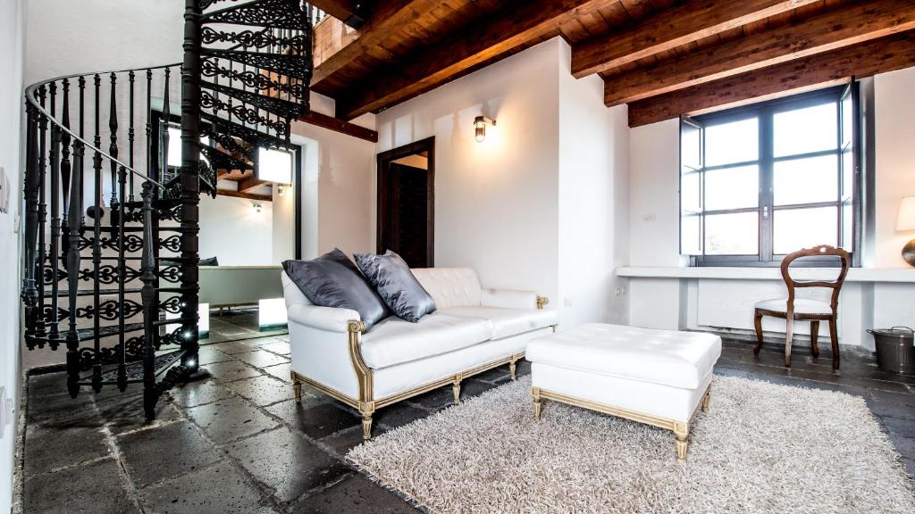 a living room with a white couch and a chair at Faro Capo Spartivento in Chia
