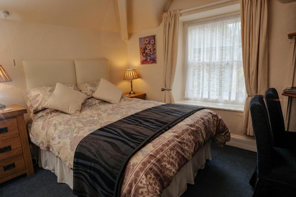 Un dormitorio con una cama grande y una ventana en Ivy House B&B, en Dolgellau