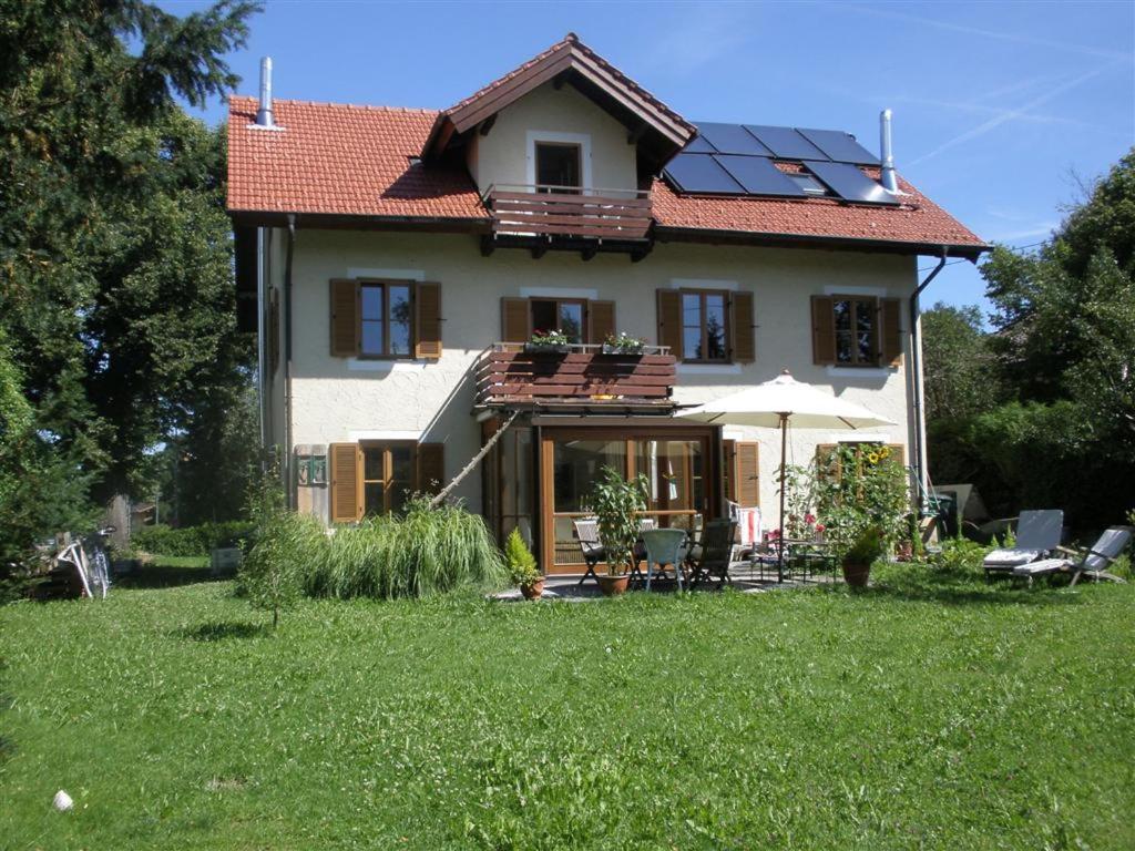 une maison avec des panneaux solaires sur le toit dans l'établissement Ferienwohnung am Seidlpark, à Murnau am Staffelsee
