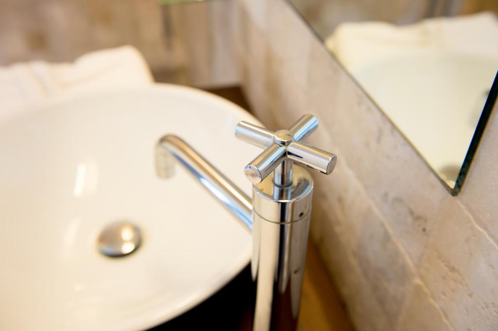 a white sink with a silver cross on it at Faro Capo Spartivento in Chia