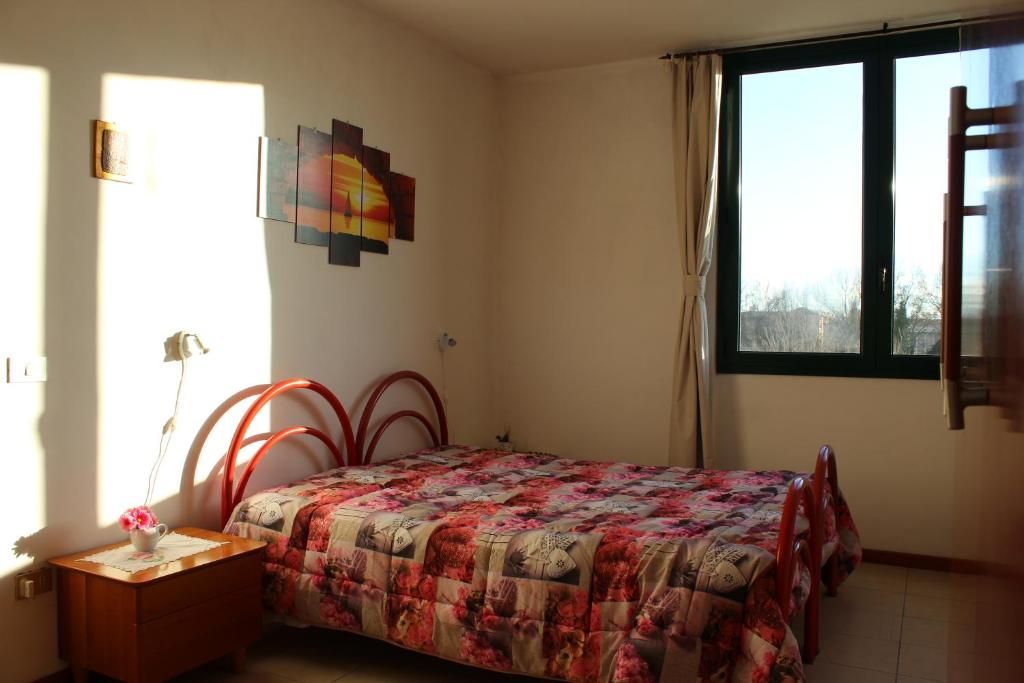 een slaapkamer met een bed, een tafel en een raam bij Oasi del piacere in Pisa