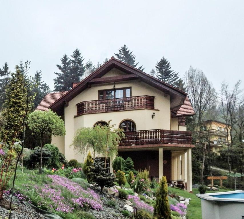 une maison avec un balcon au-dessus d'un jardin dans l'établissement Willa Wierchy, à Szczyrk
