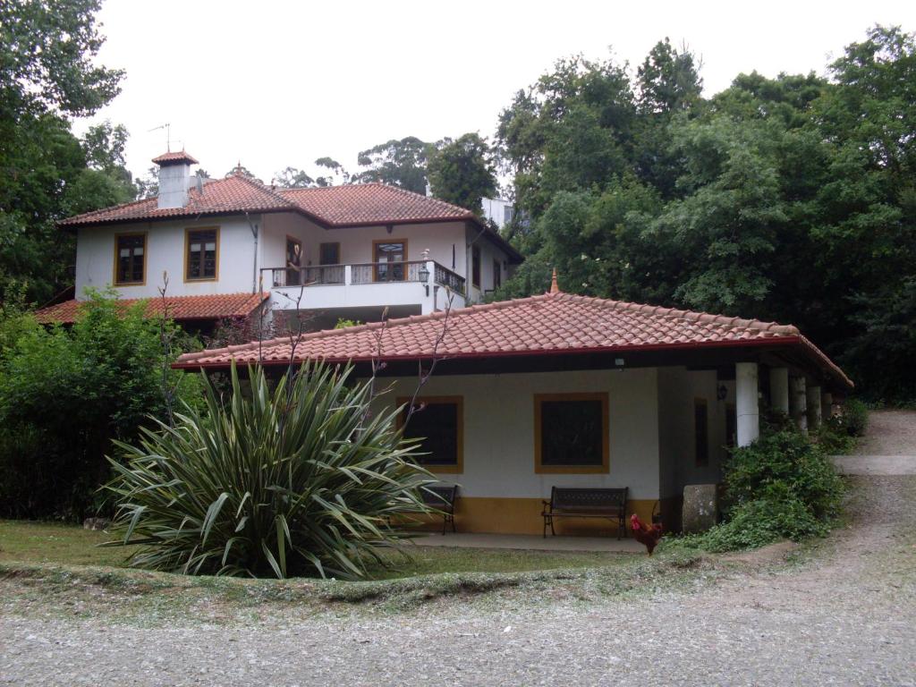 una casa con un banco delante de ella en Casa do Moinho Rural campo e praia , 9 pessoas, animais benvindos en Espinho