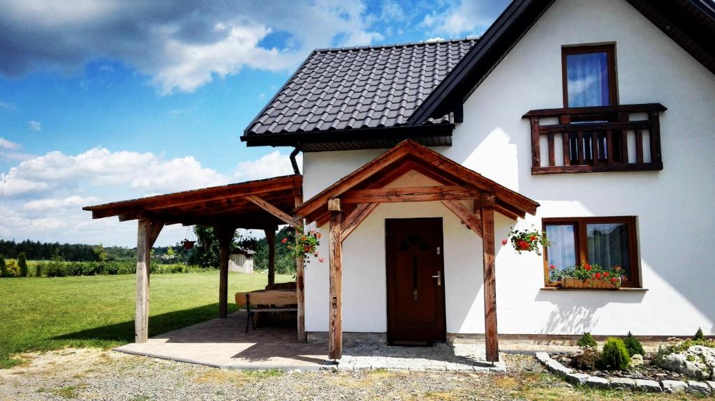a white house with a gazebo at Świerkowa Chata in Bałtów