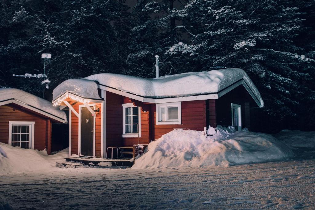 a small house covered in snow at night at Pellon Helmi Holiday Cottages in Pello