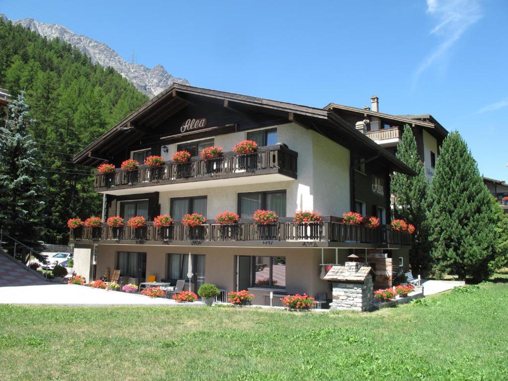 a building with flowers on the balconies of it at Ferienhaus Alea in Saas-Grund
