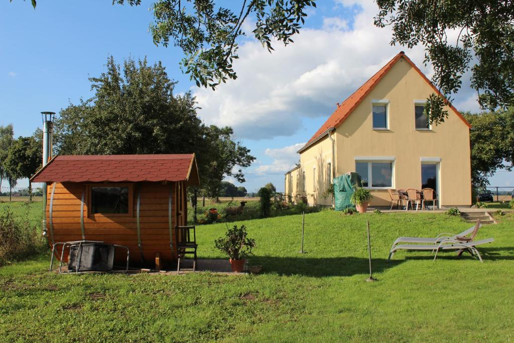 uma pequena casa e um banco num quintal em Ferienhaus Loose 8 em Letschin
