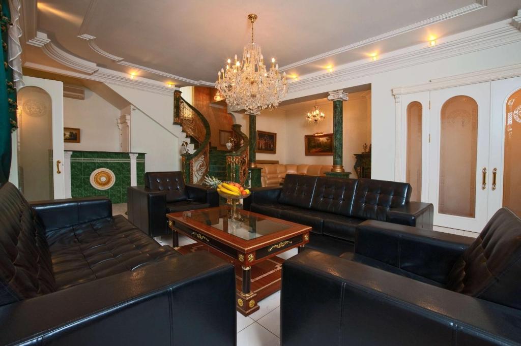 a living room with black leather furniture and a chandelier at Апартаменты на Ковтюха in Krasnodar