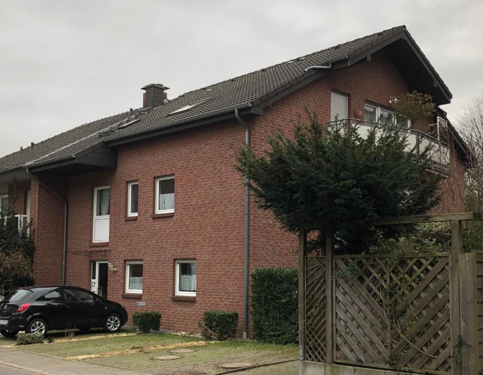 ein rotes Backsteinhaus mit einem schwarzen Auto vor dem Haus in der Unterkunft Casa Vesalia in Wesel