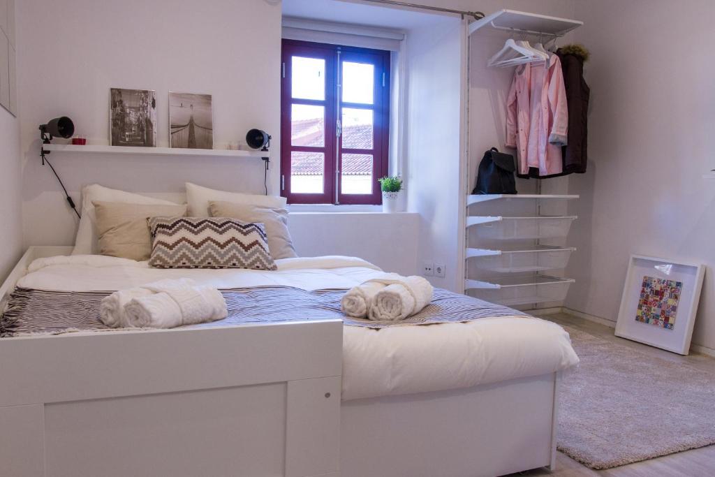 Un dormitorio con una cama blanca con toallas. en Casa com Graça - Fully equiped Studio in the Historical Center, en Lisboa