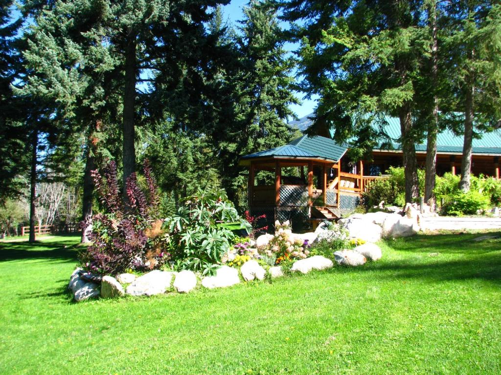 a garden with a gazebo in a yard at Shadow Mountain Cabins in Riondel