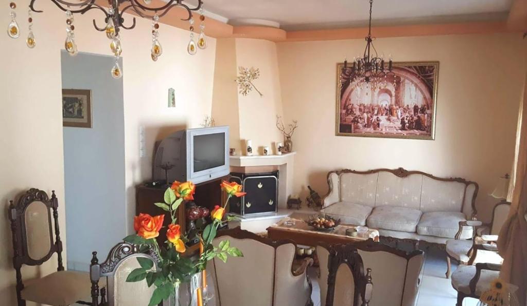ein Wohnzimmer mit einem Sofa und einem Tisch mit Blumen in der Unterkunft Irini's home in Volos