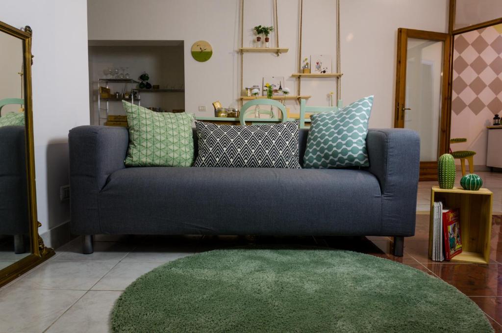 ein blaues Sofa im Wohnzimmer mit grünem Teppich in der Unterkunft Alloggio OpenSpace da Irene in San Giovanni Lupatoto