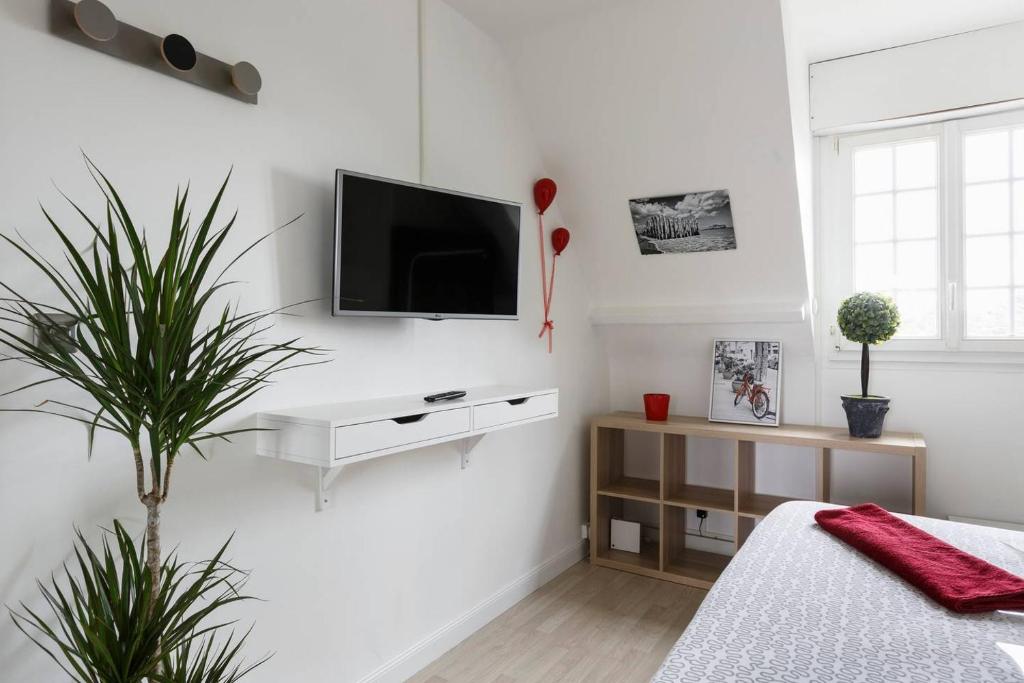 - une chambre blanche avec une télévision sur un mur blanc dans l'établissement Cosy Solidor Beach View, à Saint-Malo