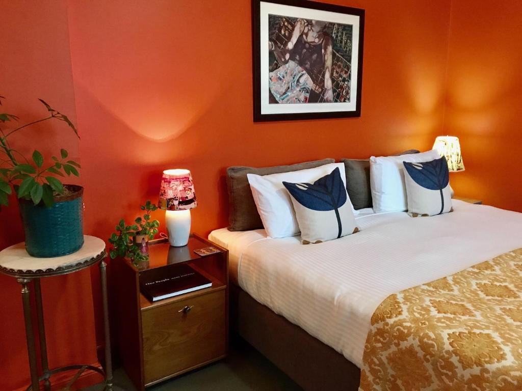 a hotel room with two beds with orange walls at Vine Valley Inn in Cessnock