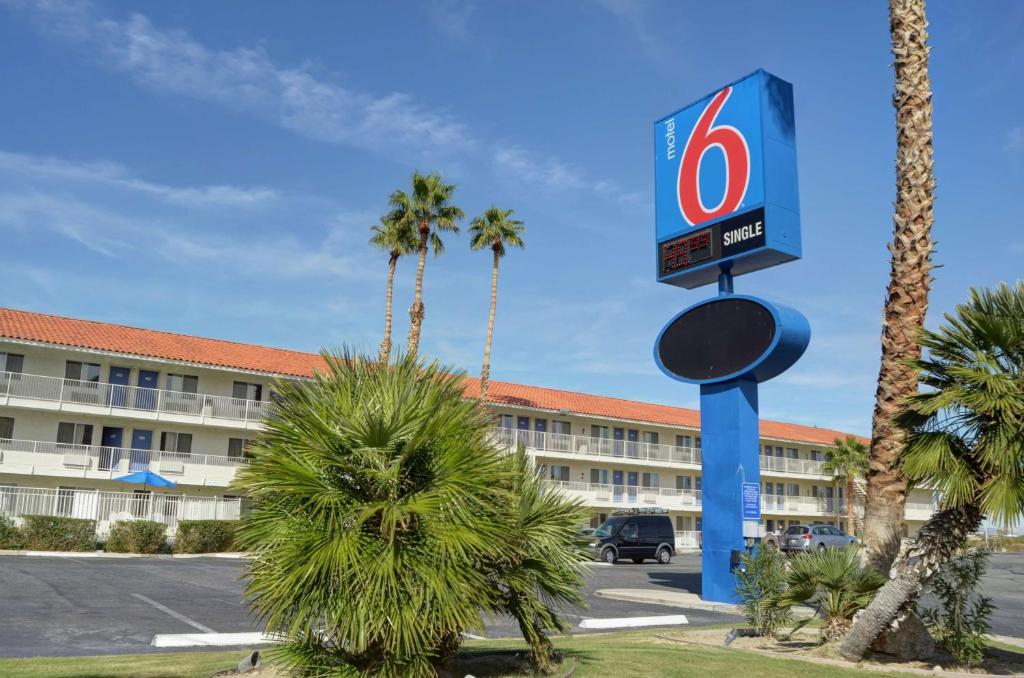 a sign in front of a hotel with palm trees at Motel 6-Twentynine Palms, CA in Twentynine Palms