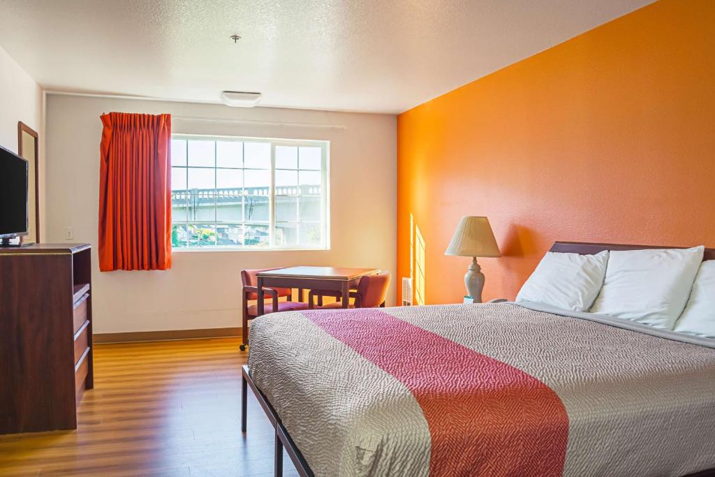 a bedroom with a bed and a desk and a window at Motel 6-Newport, OR in Newport