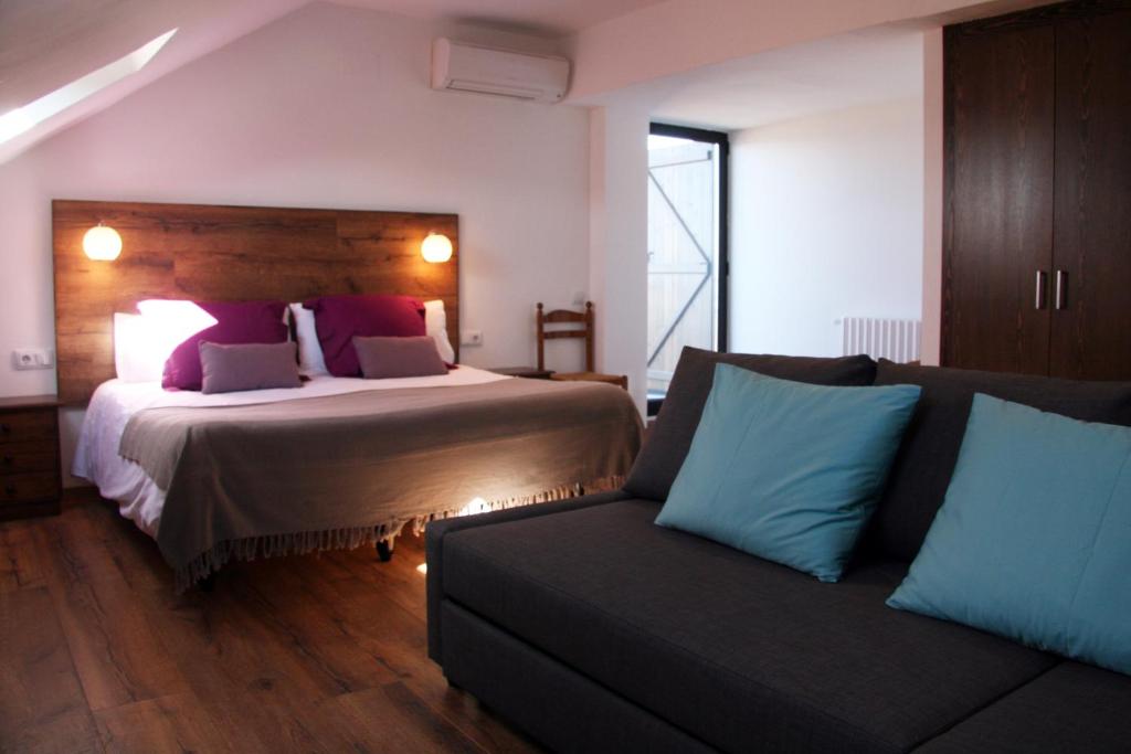 Habitación de hotel con cama y sofá en Cal Portalé, en Claverol