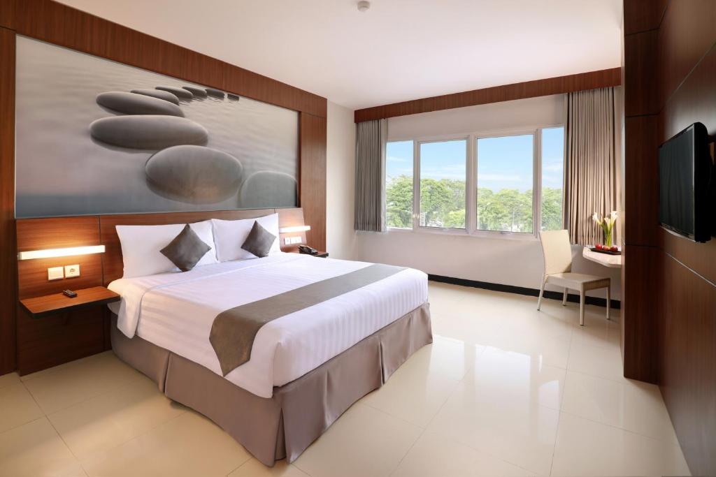 Postel nebo postele na pokoji v ubytování Hotel Neo Palma Palangkaraya by ASTON