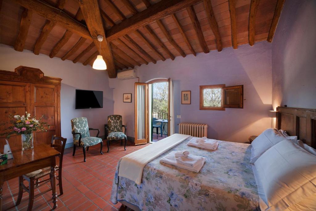 Schlafzimmer mit einem Bett, einem Tisch und Stühlen in der Unterkunft Le Mandrie di Ripalta in Montespertoli