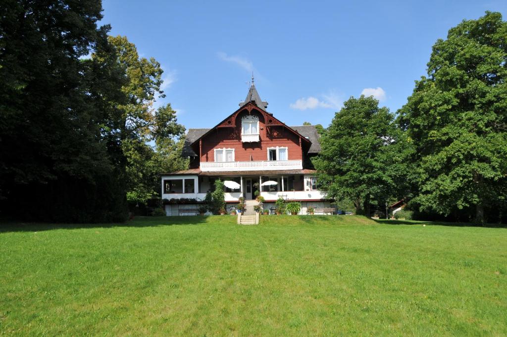 a large house on a field with trees at Jagdschloss Fahrenbühl Hotel Garni in Kirchenlamitz