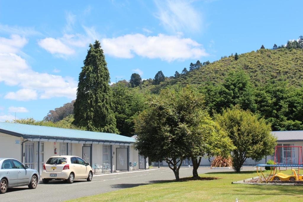 un edificio con auto parcheggiate di fronte a una montagna di Fairy Springs Motel a Rotorua