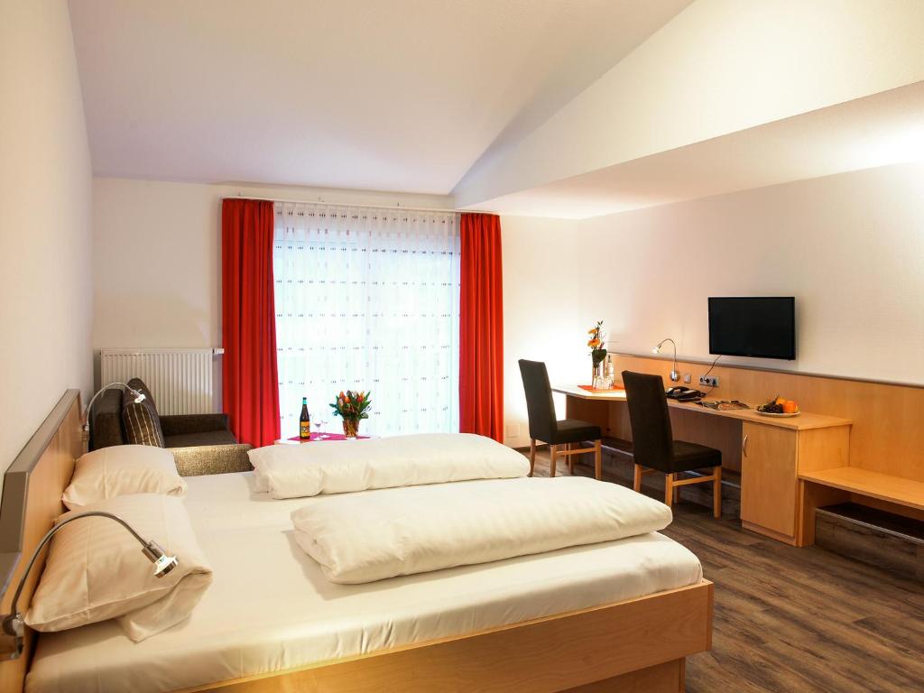 a hotel room with two beds and a desk with a computer at Hotel Gasthof zum Biber in Motten