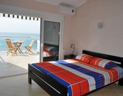 a bedroom with a bed and a view of the ocean at Pansion Vongola in Utjeha
