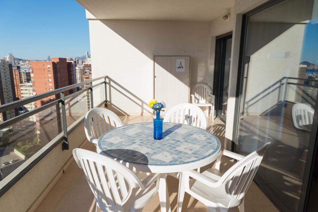 Hotel Apartamento La Niña 18 by Gestaltur, a table with chairs and a vase on a balcony at Apartamento La Niña 18 by Gestaltur in Benidorm