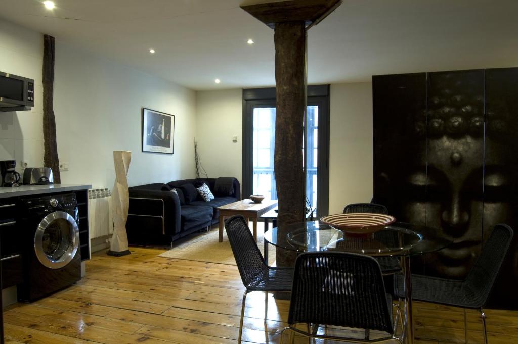 a living room with a table and chairs and a living room at Apartamentos Ondoloin in Vitoria-Gasteiz