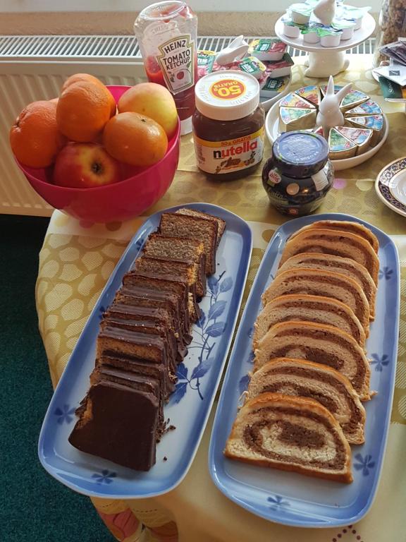 two slices of cake and bread on a table with fruit at Pension Sunset Mezirolí in Nová Role