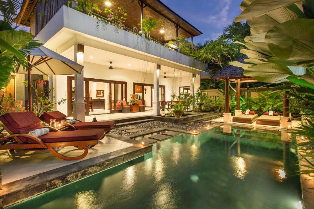 a villa with a swimming pool in front of a house at Villa Sedap Malam Seminyak by Best Deals Asia Hospitality in Seminyak