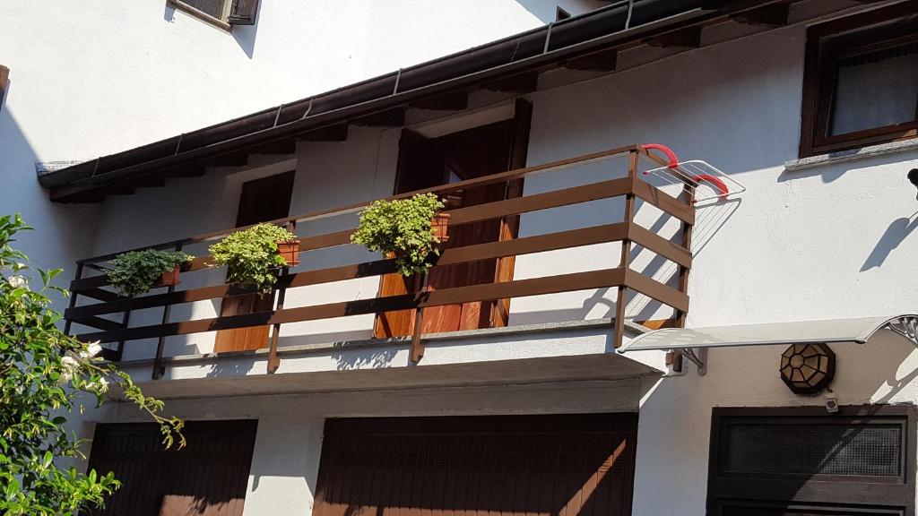 uma varanda com vasos de plantas ao lado de uma casa em La Casetta em Stresa