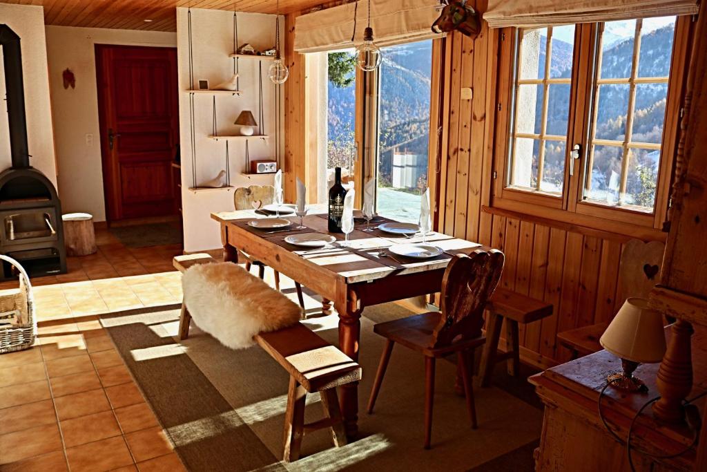 uma sala de jantar com uma mesa de madeira e cadeiras em Magnifique chalet pour 10 personnes à Vercorin em Vercorin