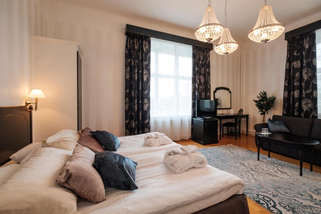 a living room with a large white bed in a room at Badhotellet Spa & Konferens in Tranås