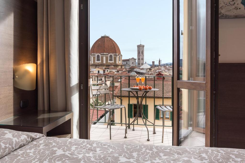 a bedroom with a view of a city from a balcony at Hotel Bellavista in Florence