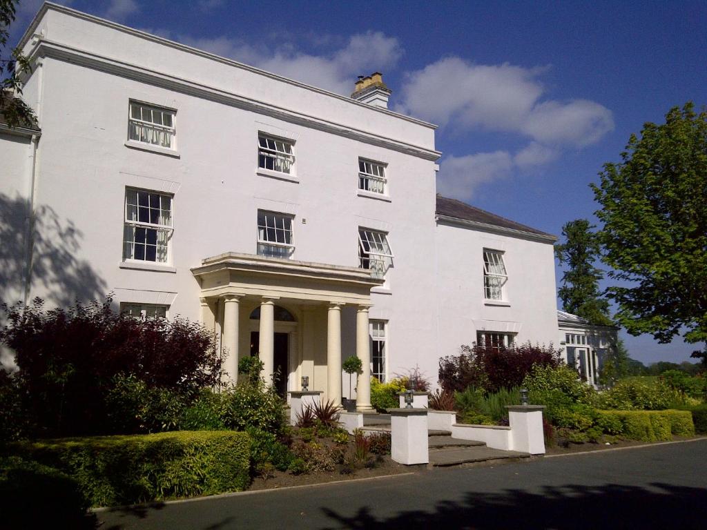 um edifício branco com um alpendre e colunas em Fishmore Hall Hotel and Boutique Spa em Ludlow