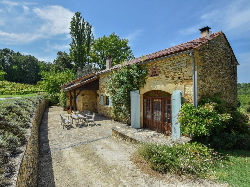 a brick building with chairs and tables outside at Traditional holiday home with pool in Saint-Cernin-de-lʼHerm