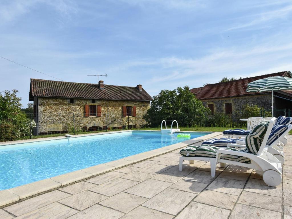 - une piscine avec 2 chaises longues à côté d'une maison dans l'établissement Stone house with private pool, à Villefranche-du-Périgord