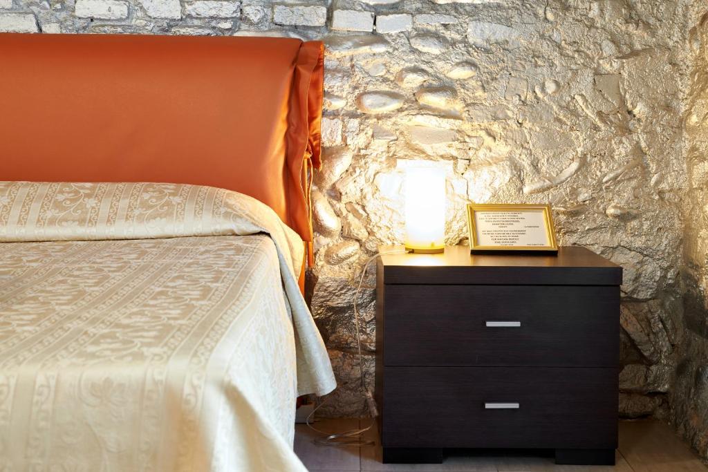 a bedroom with a bed and a nightstand with a lamp at Antico Borgo in Bergamo