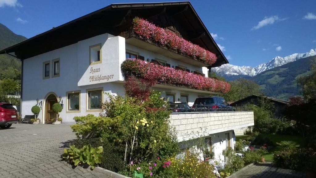 un edificio con flores a un lado. en Garni Mühlanger en Tirolo