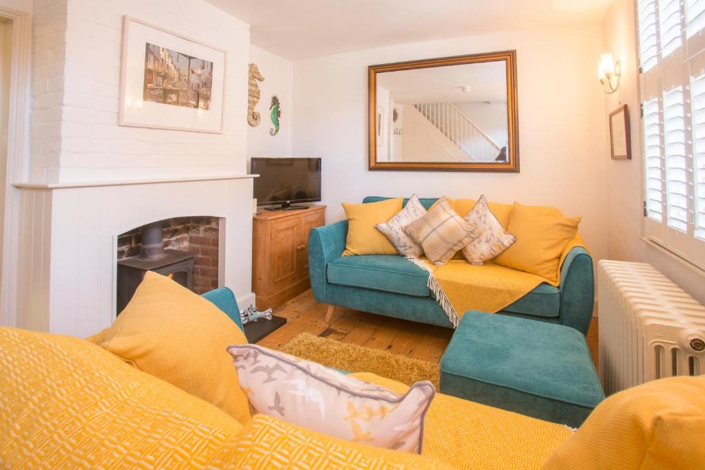 a living room with a couch and a fireplace at Pugwash in Aldeburgh