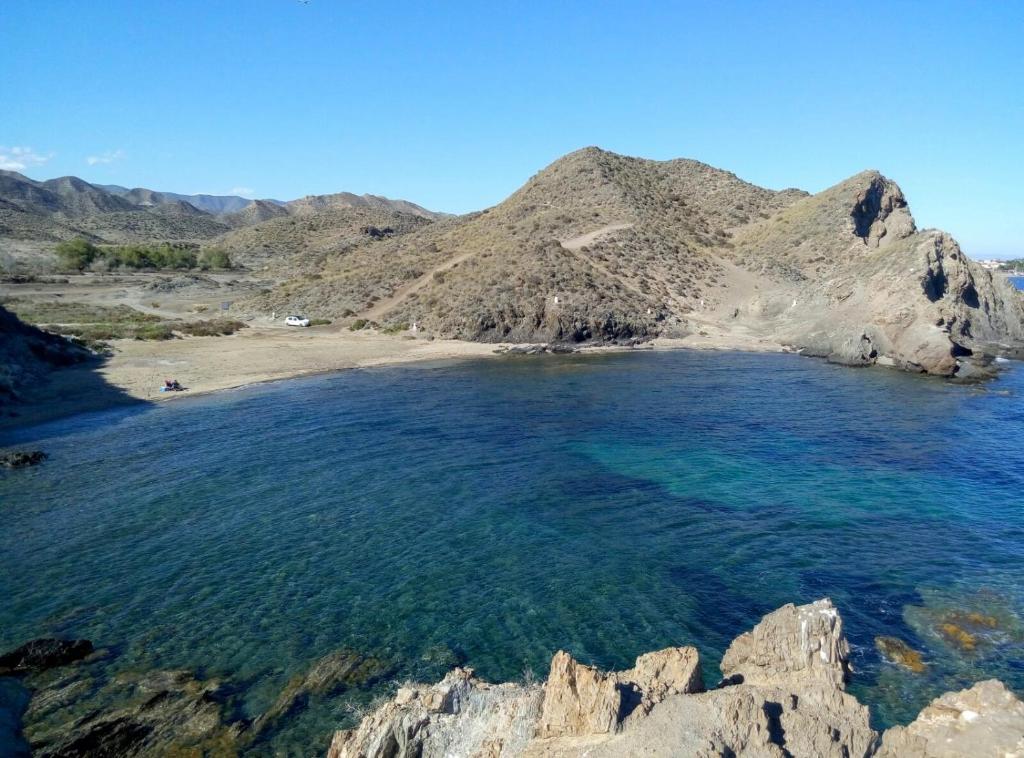 uma vista para uma praia com montanhas ao fundo em Miramar Habitaciones em Calabardina