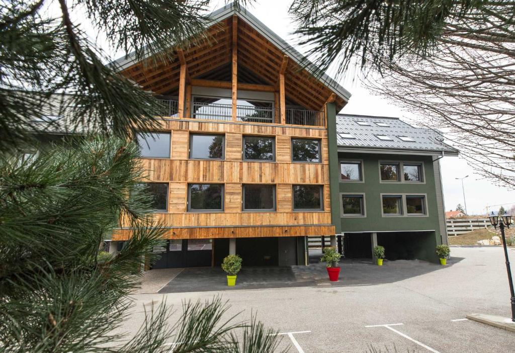 - un grand bâtiment avec un balcon en haut dans l'établissement LES CABANES De La Maison Rouge, à Barberaz