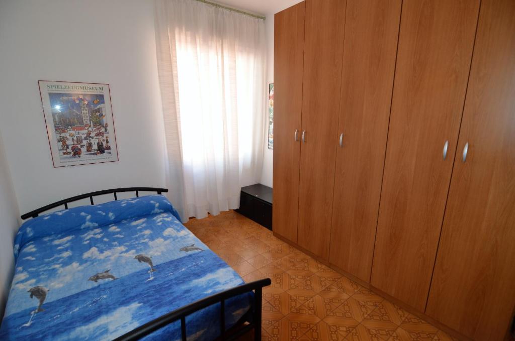 レヴァントにあるGabry apartmentのベッドルーム1室(青いシーツと木製キャビネット付きのベッド1台付)