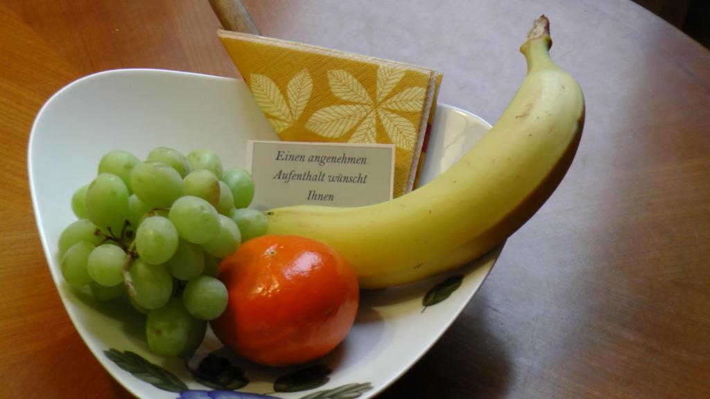 a bowl of fruit with a banana and grapes at ABT Private Rooms - Bed and Breakfast - Hannover (room agency) in Hannover
